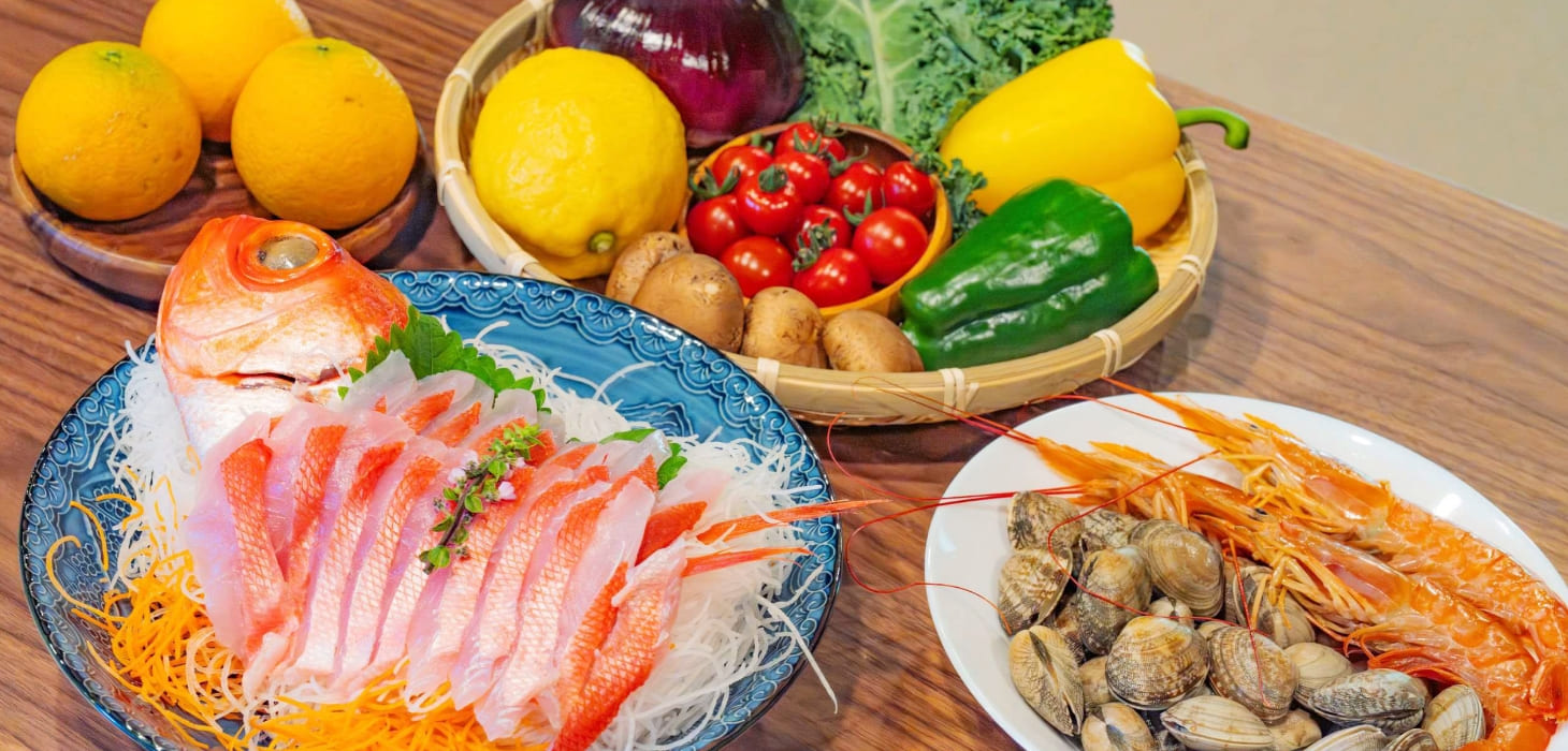 [写真] 魚介や野菜など夕食用の食材がテーブルに並ぶ様子