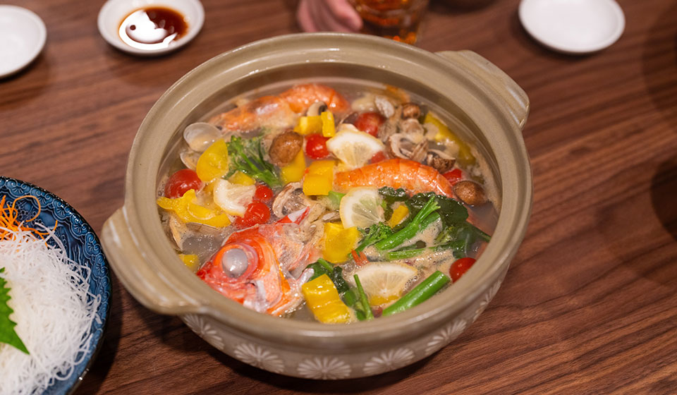 [写真] 魚介や野菜が彩りよく入った鍋料理