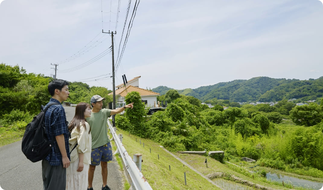 [写真] 棚田を見渡しながらガイドの説明を聞く様子