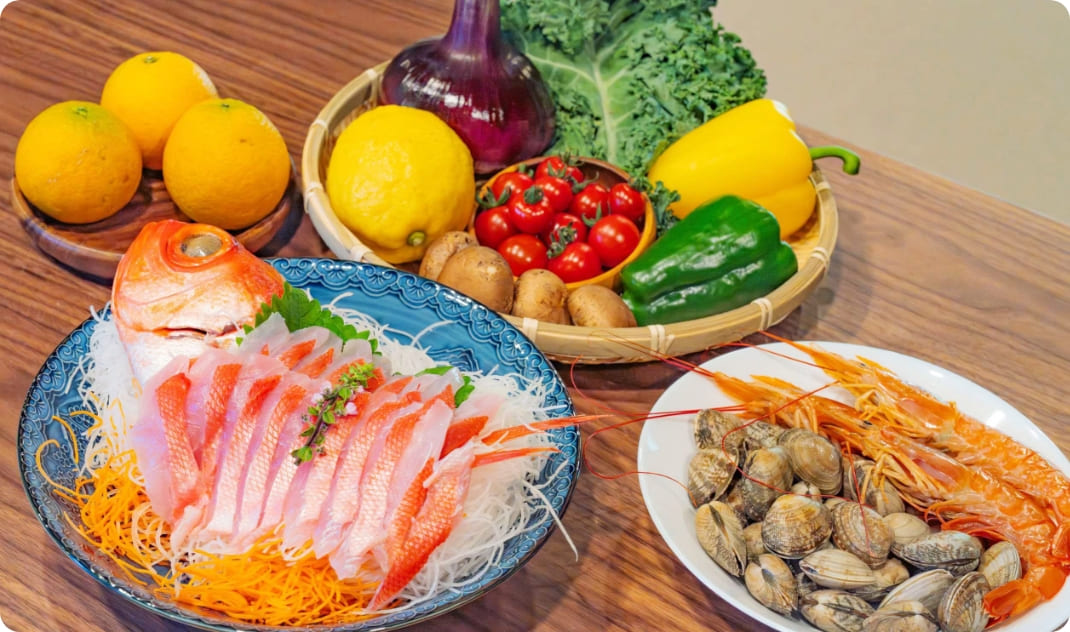[写真] 魚介や野菜など夕食用の食材がテーブルに並ぶ様子