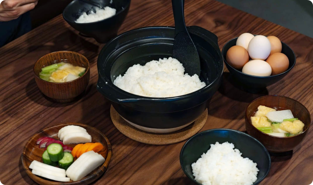 [写真] 土鍋ご飯や卵、味噌汁など朝食の食材が並ぶ様子