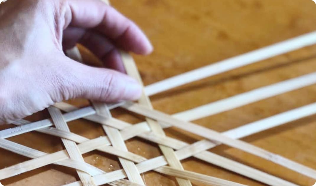 [写真] 竹ひごを編んで小物を作る手元