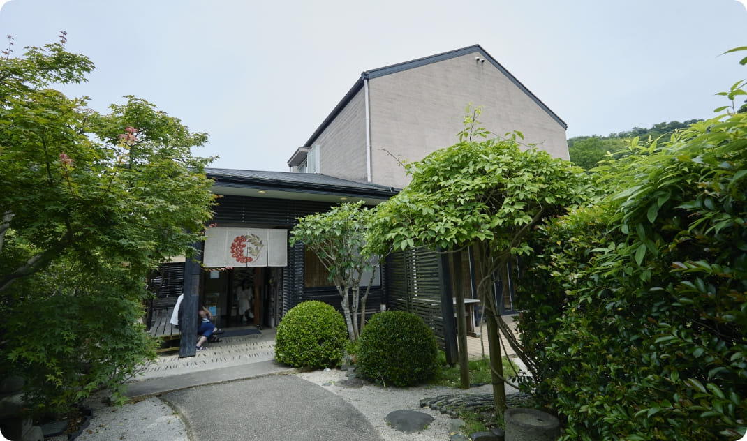 [写真] 木々に囲まれた店舗の外観