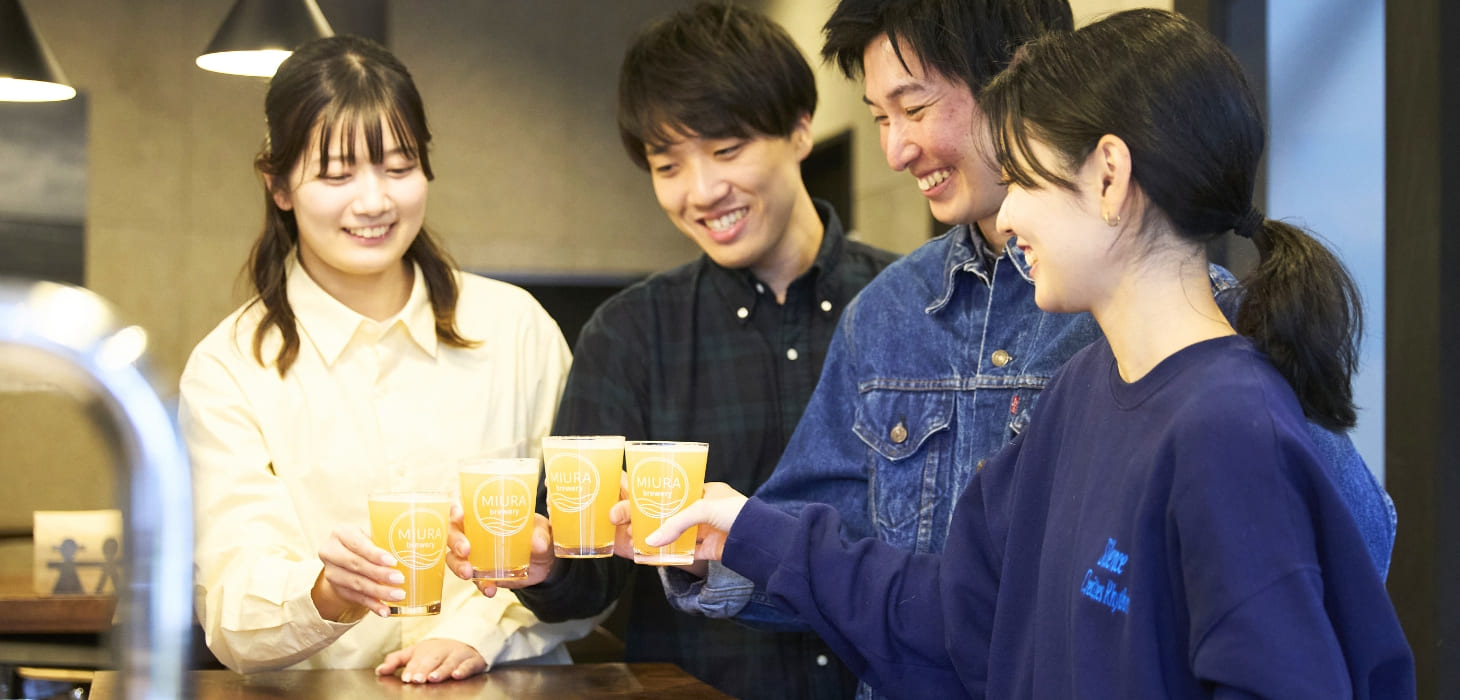 [写真] MIURA breweryのロゴが入ったグラスやボトルを手に、ビールを楽しむ人たちの笑顔