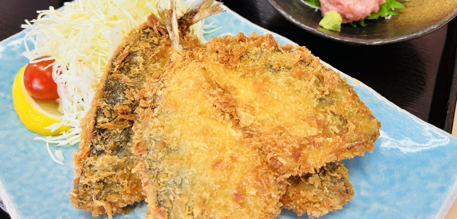 [写真] 揚げたてで衣が黄金色の、大ぶりなアジフライが2尾盛り付けられた様子