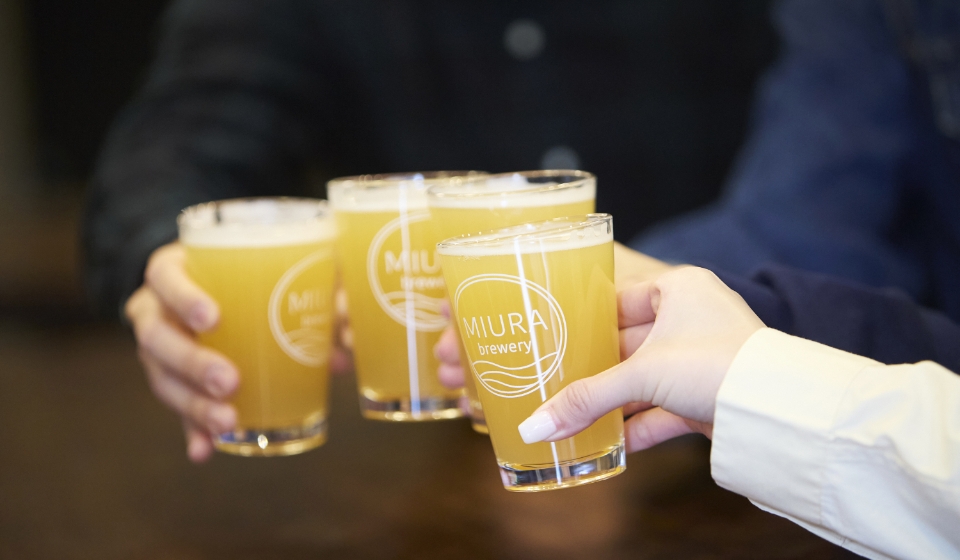 [写真] 「MIURA brewery」のロゴ入りグラスで乾杯する様子