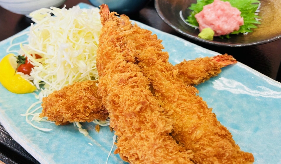 [写真] 揚げたての大きなエビフライとマグロの刺身が盛られた料理