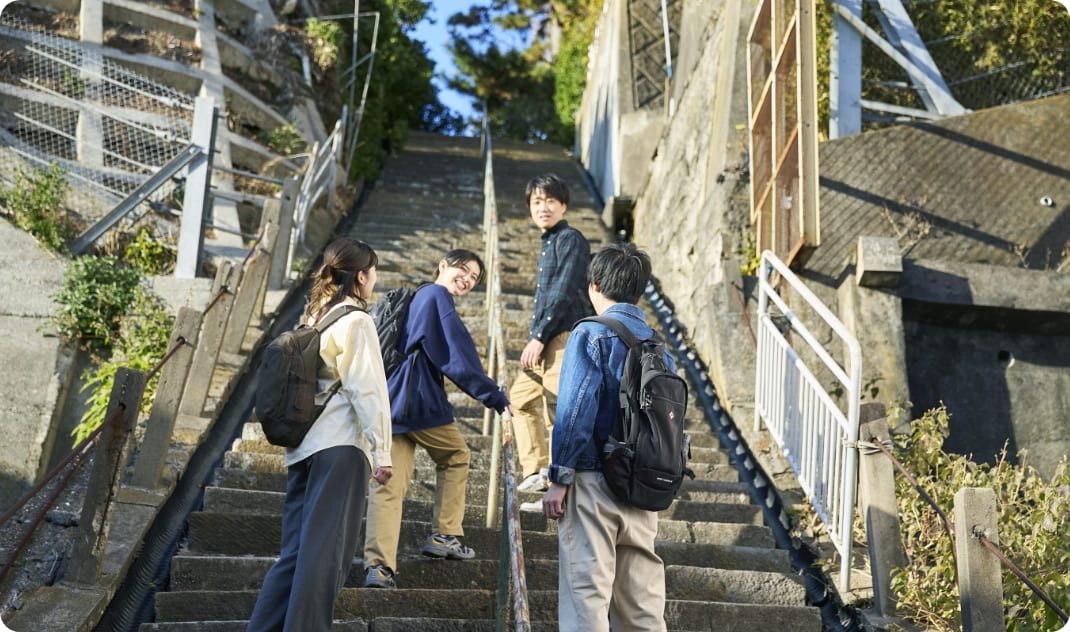 [写真] 高台へと続く長い階段を、声を掛け合いながら登る様子