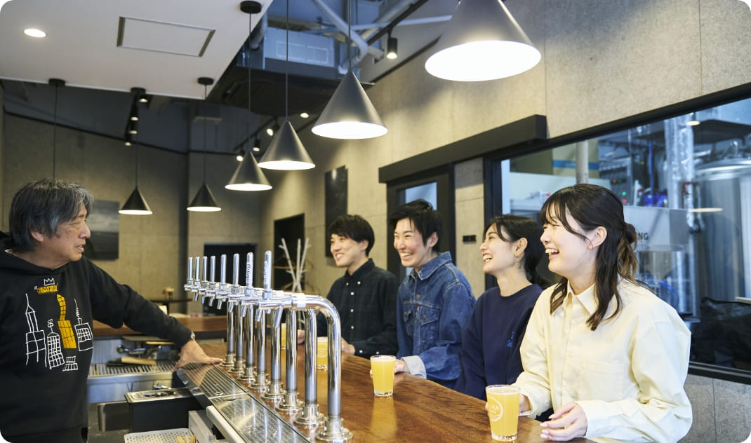 [写真] 醸造所のカウンターで、店主と会話を楽しみながらビールを味わう様子