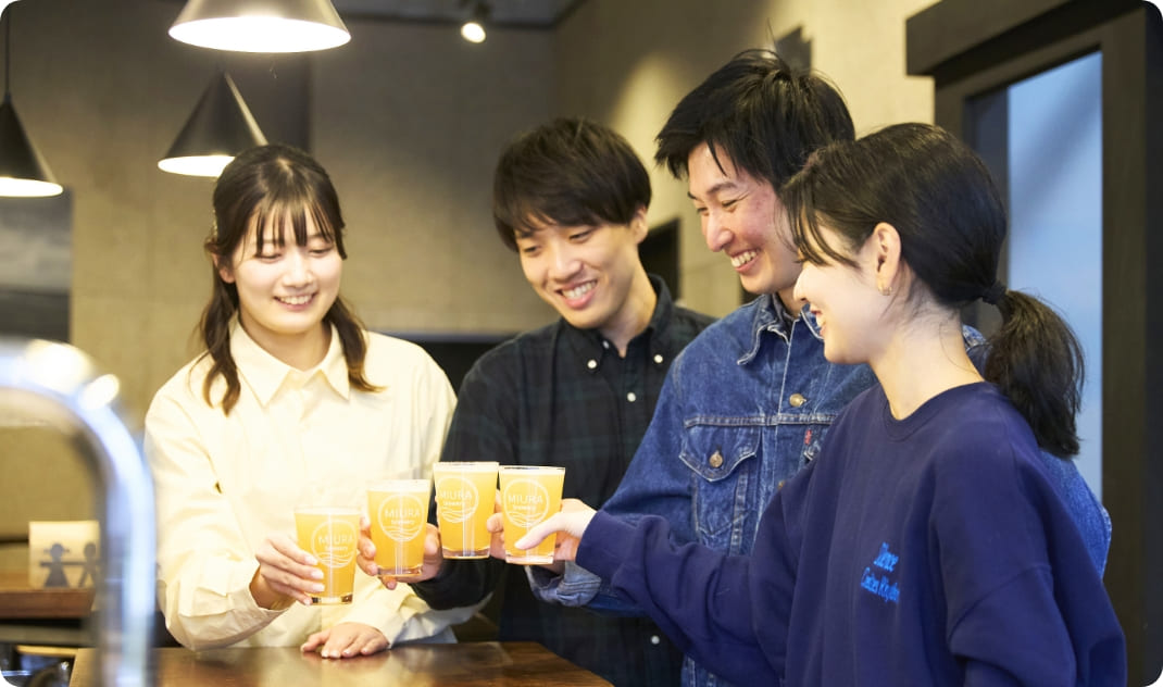 [写真] 「MIURA brewery」のロゴ入りグラスを掲げて乾杯する4人